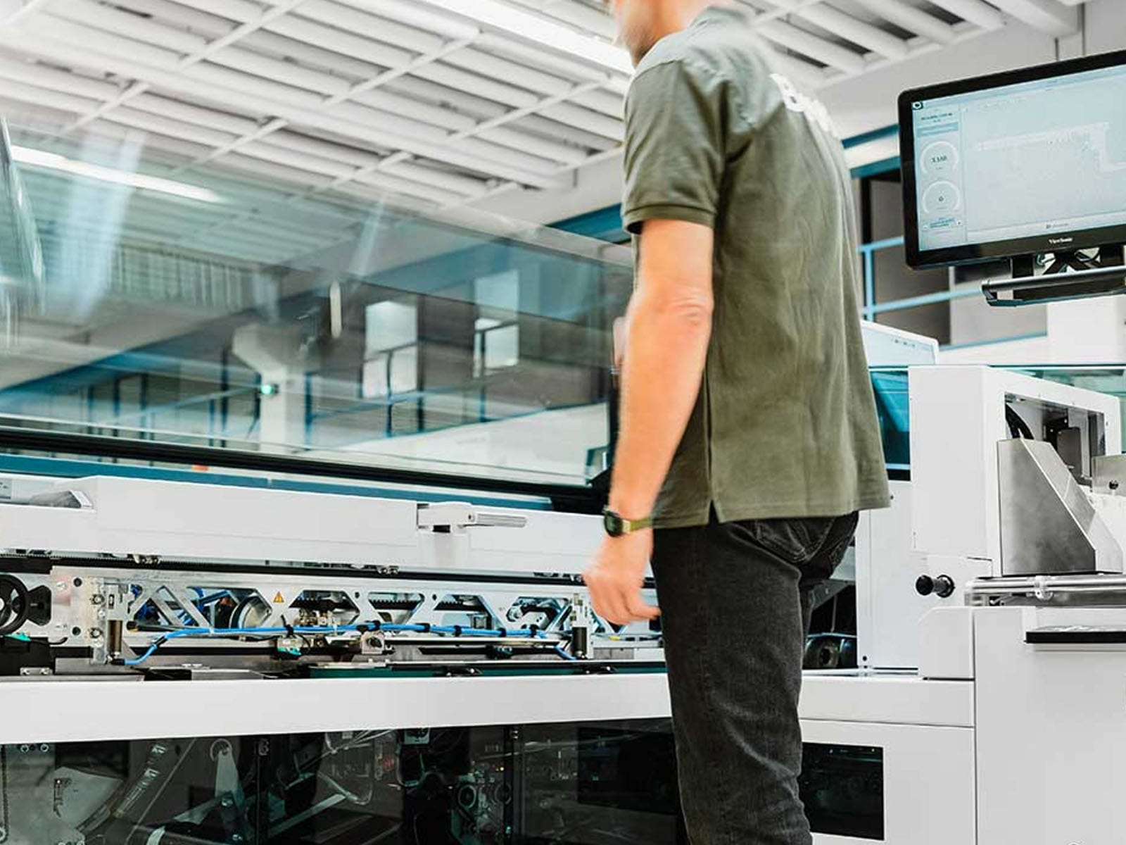 Operator Working with Advanced Printing Equipment A technician interacts with high-tech printing machinery in a modern facility.